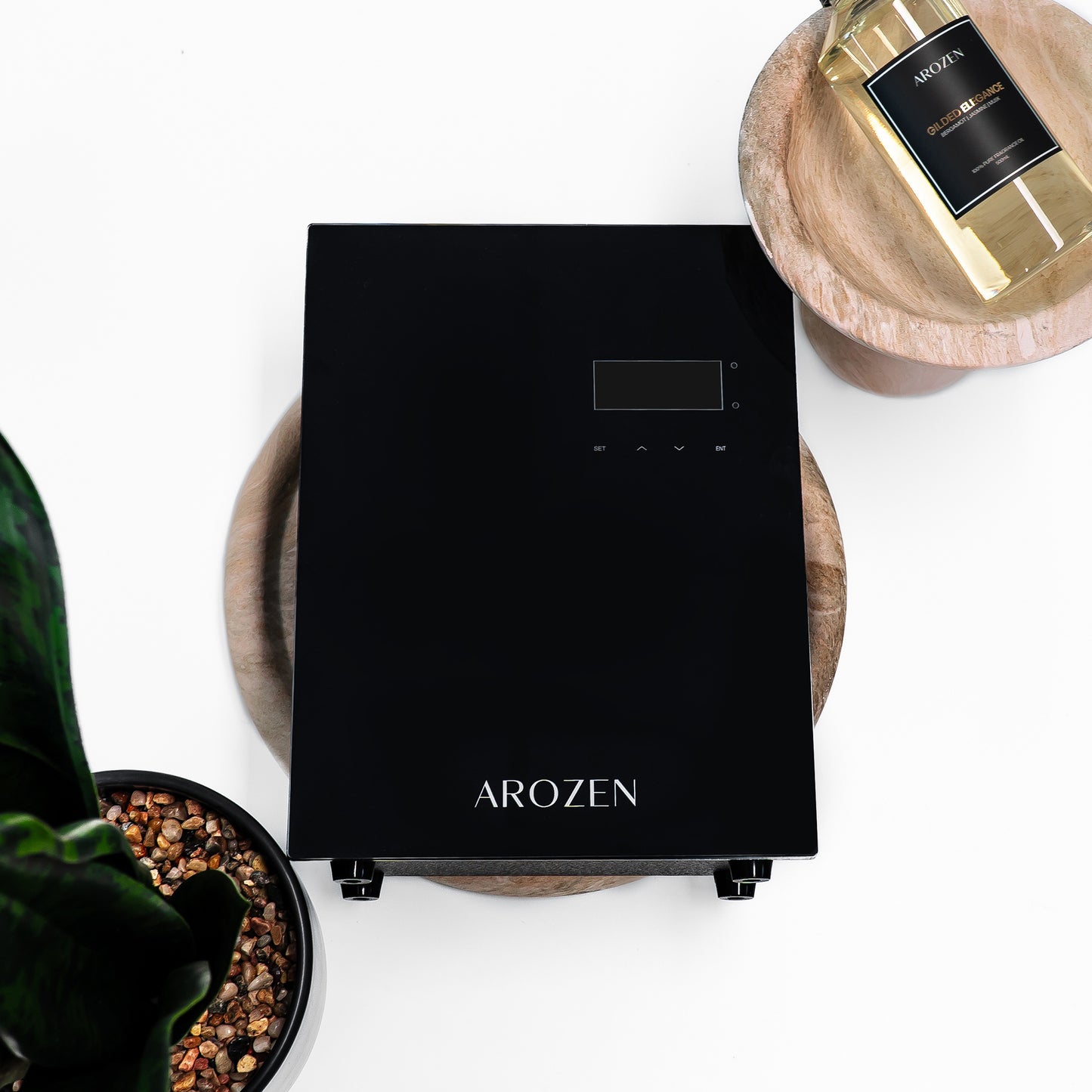 A sleek black Arozen VORTEX ULTRA ELECTRIC SCENT DIFFUSER sits on a wooden tray beside fragrance oils and a potted plant, all set against a white background.